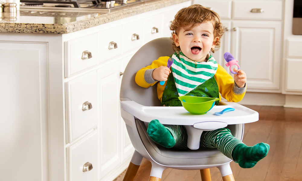 boy laughing whilst sitting in the high chair